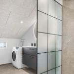 Badezimmer mit Dusche, Waschmaschine und Toilette unter Dachschrägen.