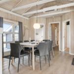 Essbereich mit Tisch, Stühlen und Kaminofen. Holzwände und Decke.