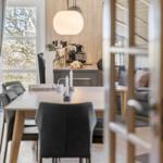 Essbereich mit Tisch, Stühlen und Blick auf Wohnzimmer.