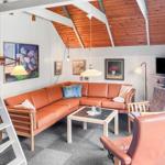 Living room with brown sofa, wooden ceiling, and wall paintings