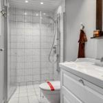 Badezimmer mit Dusche, Toilette und Waschbecken mit Spiegel