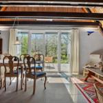 Esszimmer mit Holzdecke, Tisch mit Stühlen und Blick auf Garten