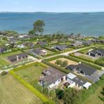 Überblick über Ferienhäuser am Wasser mit grünen Gärten und gepflasterten Wegen.