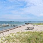 Strand mit Holzsteg und Picknicktischen am Wasser