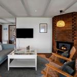 Wohnzimmer mit Sofa, Kamin und Fernseher