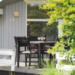 Terrasse mit Tisch, Stühlen und Weinflasche vor einem Haus mit Nummer 17.