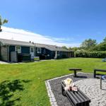 Ein Haus mit großem Garten, Spielplatz und Grillplatz im Freien.