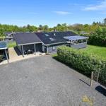 Ein Haus mit Garage, Terrasse und Garten. Eine Flagge weht im Wind.