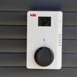 Ladestation an der Wand montiert mit Display und Steckdose.
