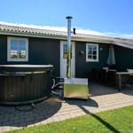 Haus mit Whirlpool, Terrasse und Sitzgelegenheiten im Freien.
