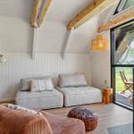 Wohnraum mit Sofa, Kamin und Glasfront zum Garten