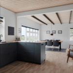 Küche mit Essbereich und Sitzgelegenheit. Holzdecke mit Balken, Fenster und moderne Einrichtung.
