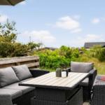 Terrasse mit Sitzgruppe, Tisch und Blick auf Grünflächen.