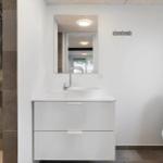 Badezimmer mit Dusche, Waschbecken und Toilette. Moderne Einrichtung.