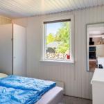 Schlafzimmer mit Bett, Kleiderschrank und Fenster zum Garten.