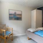 Schlafzimmer mit Bett, Stuhl und Kleiderschrank an der Wand.