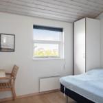 Bedroom with bed, desk, window, and wardrobe.