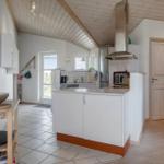 Kitchen with worktop, extractor hood, and kitchen units. Wooden ceiling and tiled floor.
