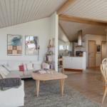 Living and dining area with sofa, table, and kitchen area in the background.