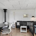 Wohn- und Essbereich mit Sofa, Esstisch und Kaminofen.
