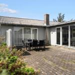 House with terrace, garden, and seating area. Through glass front to interior.