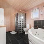 Badezimmer mit Badewanne, Toilette und Dusche aus Glasblöcken.