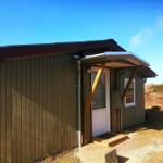 Holzhaus mit Eingangstür und Dachüberstand im Freien