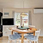 Dining room with wooden table, chairs, fireplace, and window view.