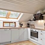 Kitchen with wooden surfaces, white cabinets, and skylights. Stainless steel appliances and kitchen utensils.