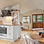 Kitchen with dining area and view into living room with sofa and door.