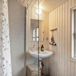 Bathroom with sink, mirror, and window. Shower curtain with floral pattern.