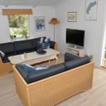 Wohnzimmer mit zwei Sitzgruppen, Fernseher und Blick auf Essbereich.