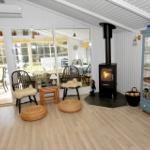 Wohnraum mit Kamin, Sitzgelegenheiten und Blick auf die Terrasse.