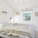 Schlafzimmer mit Bett, Fenster und Wanddekoration.