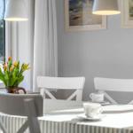 Dining room with table, chairs, and view of green field. Two pictures hang on the wall.