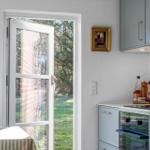 Kitchen with garden view, light blue cabinets, and countertop with oven.