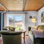 Living room with fireplace, green chairs, and view of fields.
