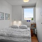 Bedroom with bed, window, and wall pictures.