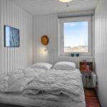 Bedroom with bed, window, and wall decor.