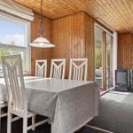Esszimmer mit Tisch, Stühlen und Blick auf Außenbereich.