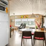 Kitchen with refrigerator and microwave. Dining area with table, chairs, and stove.