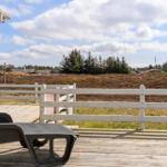Deck with lounge chair and view of meadows and trees.