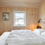 Bedroom with wooden walls, bed, and window.