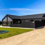 Moderne schwarze Villa mit großem Garten und Trampolin. Hausnummer 108.