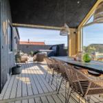 Terrasse mit Esstisch und Stühlen, Blick auf Garten und Pool.