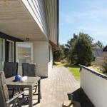 Terrasse mit Tisch, Stühlen und Blick auf Grünfläche und Nachbarhaus.