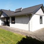 Moderne Villa mit Terrasse und Solaranlage. Grünfläche und gepflasterter Hof.