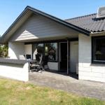 Wohnhaus mit Terrasse, Garten und Sitzgelegenheit. Dach mit Solaranlage.
