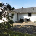 Haus mit Terrasse, Garten und Sitzgruppe unter freiem Himmel.