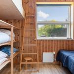 Room with daybed, ladder, and window overlooking greenery.